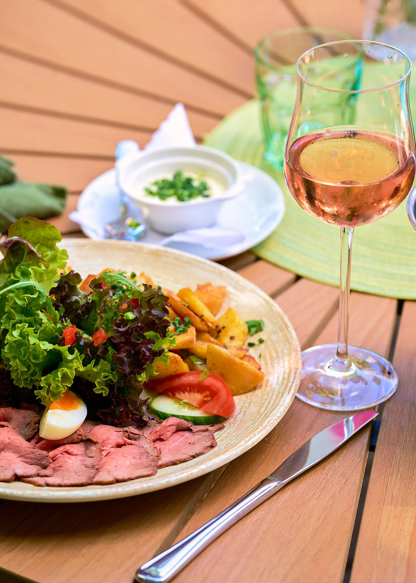 Teller und Roséwein auf der Gartenterrasse
